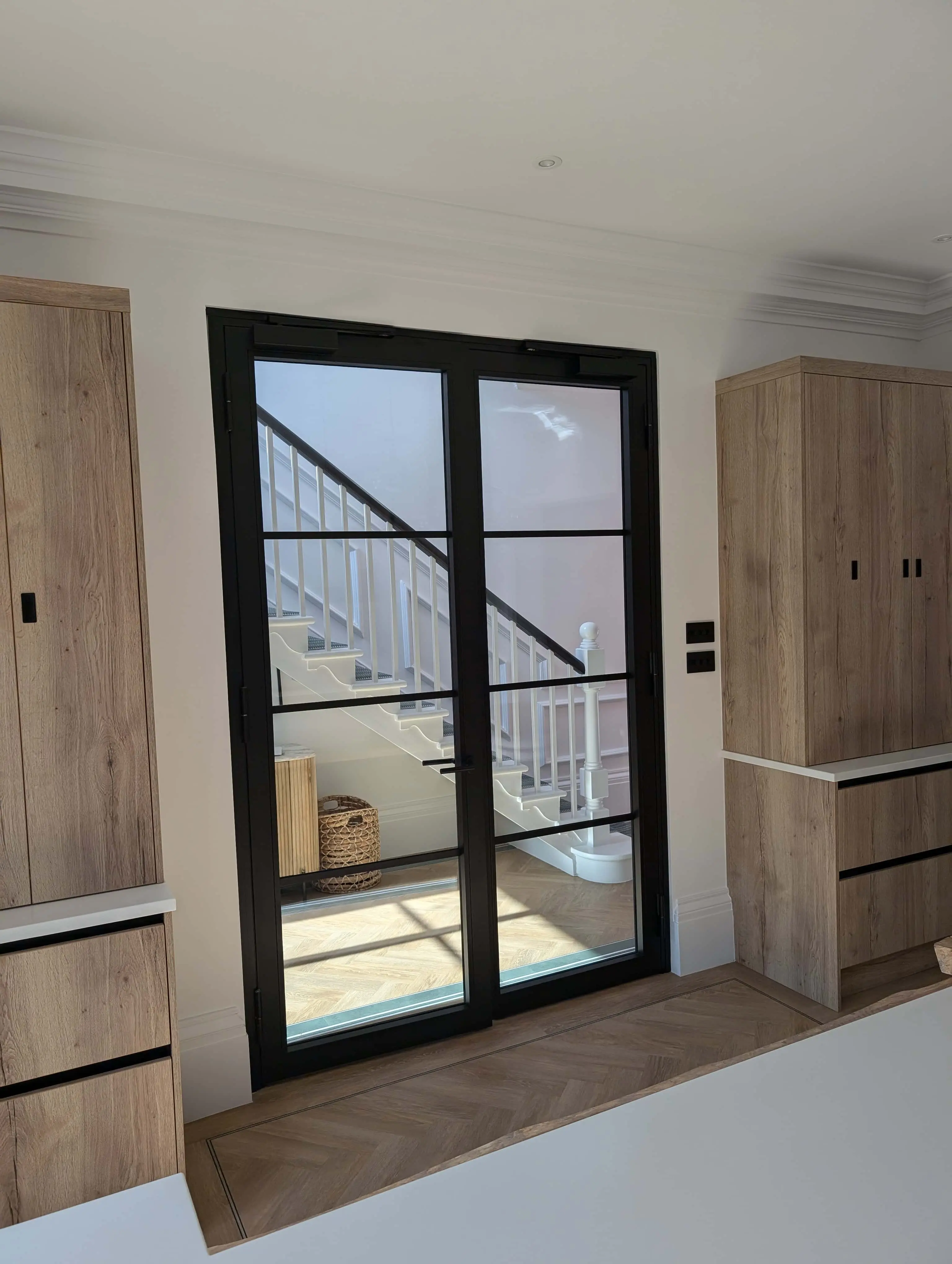 carlton-terrace-critall-style-glazed-doors-staircase-acre-design.webp Critall-style glazed doors connecting kitchen to staircase at Carlton Terrace townhouse renovation