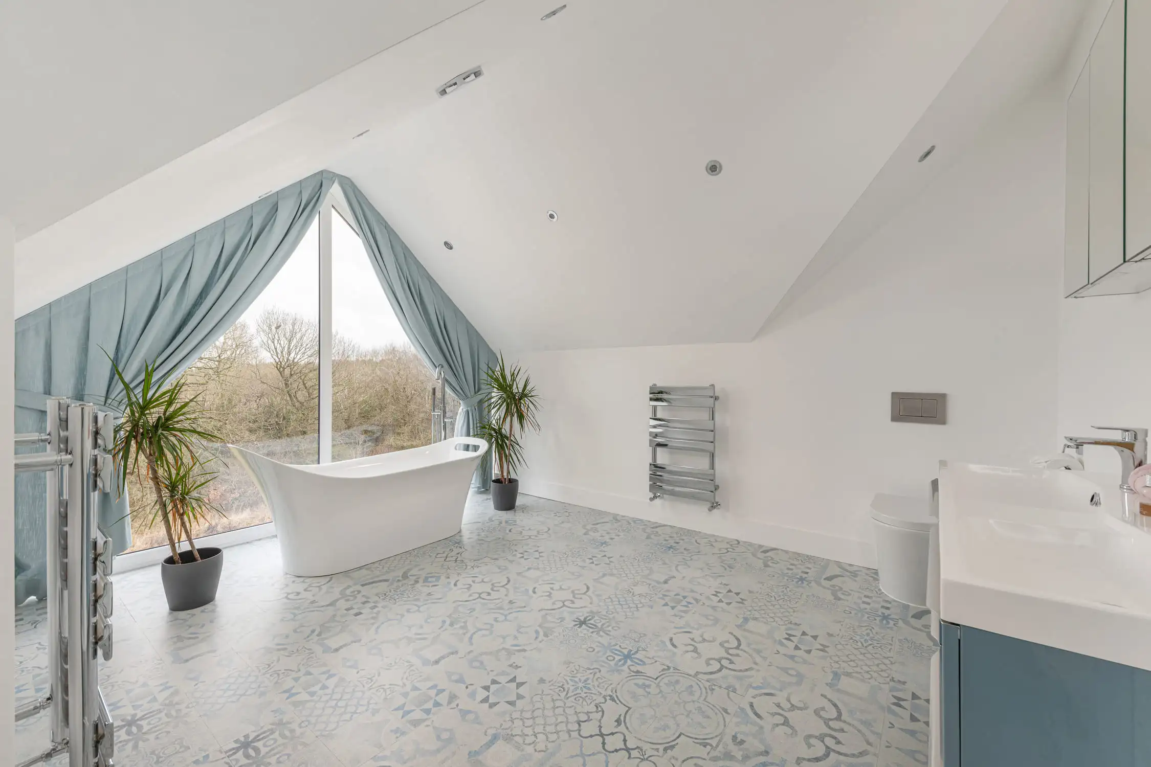 Hazelwood-Road-Great-Park-Gosforth-Newcastle-Self-Build-Home-Design-Acre-bathroom-large-view-panoramic-window-luxury A bath with a view, this oval bath in white looks out over the surrounding woodland through a floor to ceiling apex window, draped in lavish curtains. Large self build home designed by Acre Design Newcastle on Hazelwood Road, Great Park.