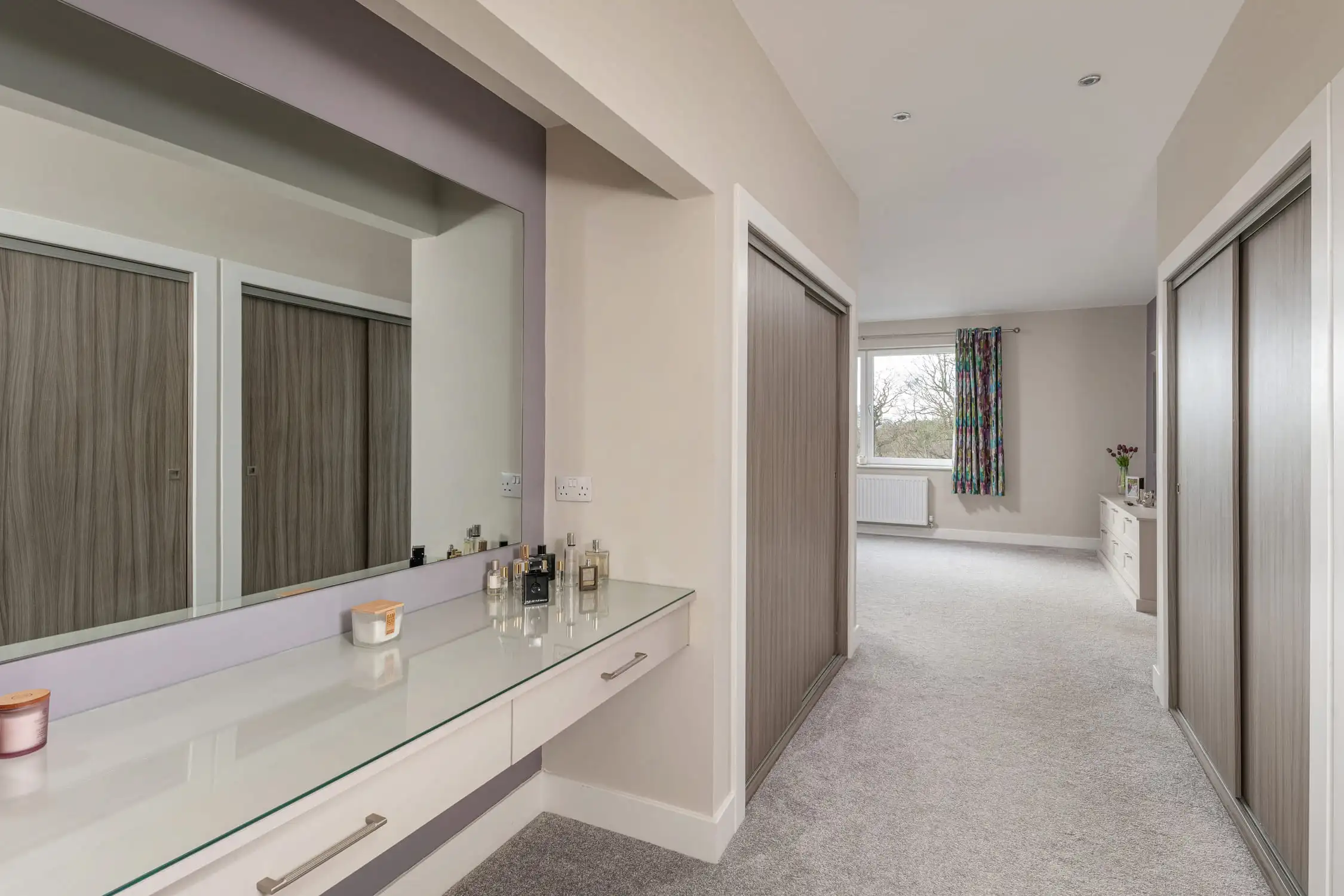 Hazelwood-Road-Great-Park-Gosforth-Newcastle-Self-Build-Home-Design-Acre-his-and-hers-bathroom-vanity-dressing-room Large self build home designed by Acre Design Newcastle on Hazelwood Road, Great Park. His and hers vanity and dressing area in neutral colours for a calming and peaceful place to prepare for the day. Brown cupboards and large mirrors behind a vanity unit.