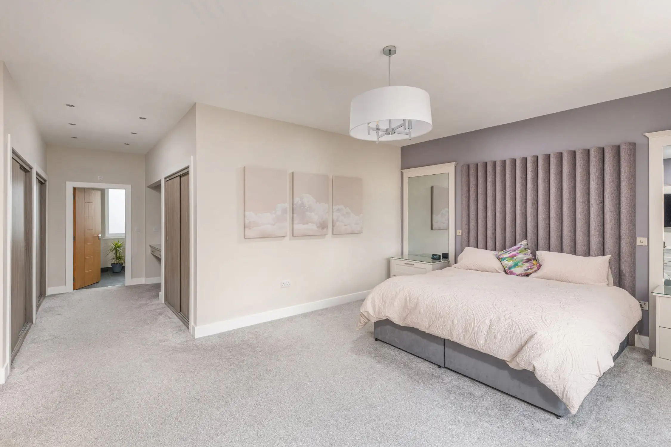 Hazelwood-Road-Great-Park-Gosforth-Newcastle-Self-Build-Home-Design-Acre-master-suite-large-bedroom Large self build home designed by Acre Design Newcastle on Hazelwood Road, Great Park. MAster bedroom featuring panelling behind large super king size bed. Modern, simple design with off white walls and bedding and a calming feel.