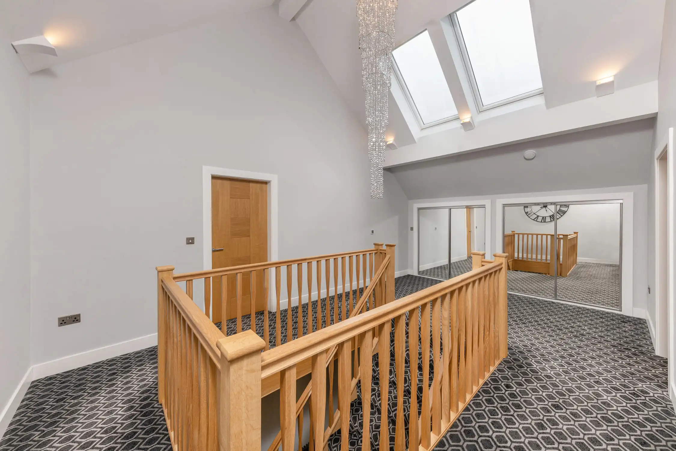 Hazelwood-Road-Great-Park-Gosforth-upstairs-landing-self-build-design-acre-newcastle Large self build home designed by Acre Design Newcastle on Hazelwood Road, Great Park. Stairway built in oak with large velux windows above allowing maximum light in the upper hallways area. Soft, patterned carpet and elegant oak doors to the upstairs rooms of this new build home.