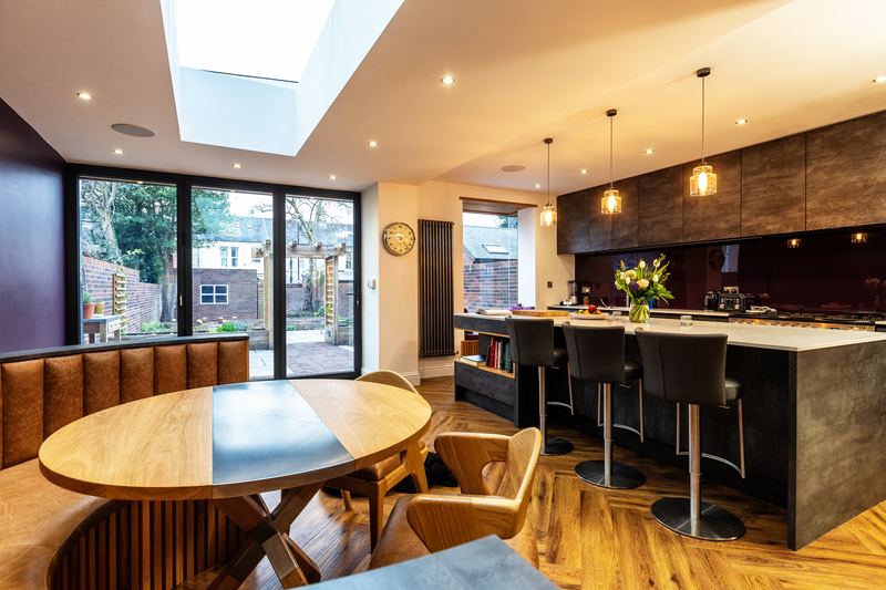 Completed kitchen extension in Jesmond, Newcastle, with rooflights, island seating and a dining table beside the garden doors