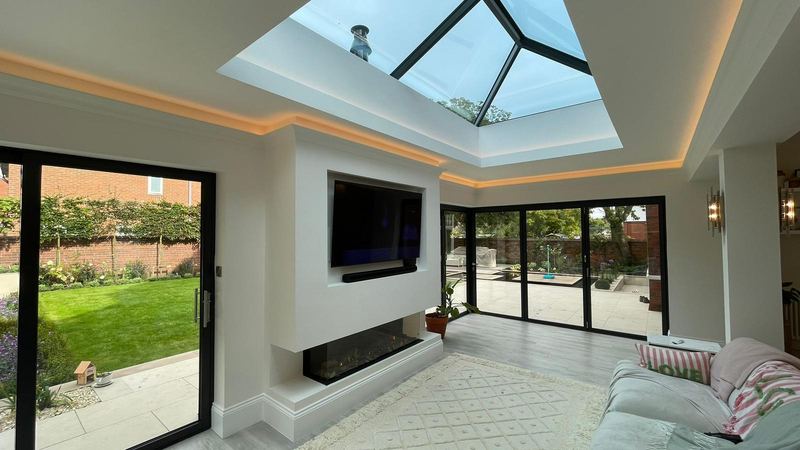 Living space inside a completed orangery-style rear extension in Whitley Bay, with a roof lantern and sliding doors to the garden