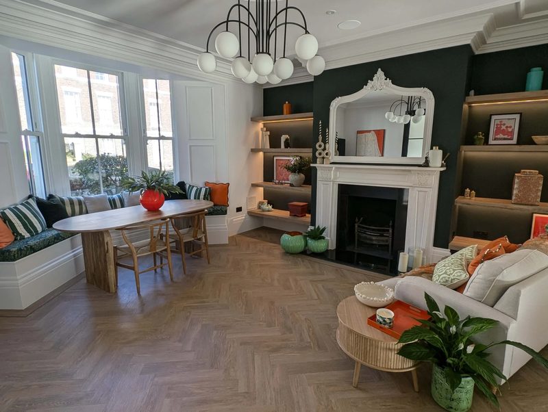Renovated period living room with a restored fireplace and built-in shelving in a historic Newcastle home