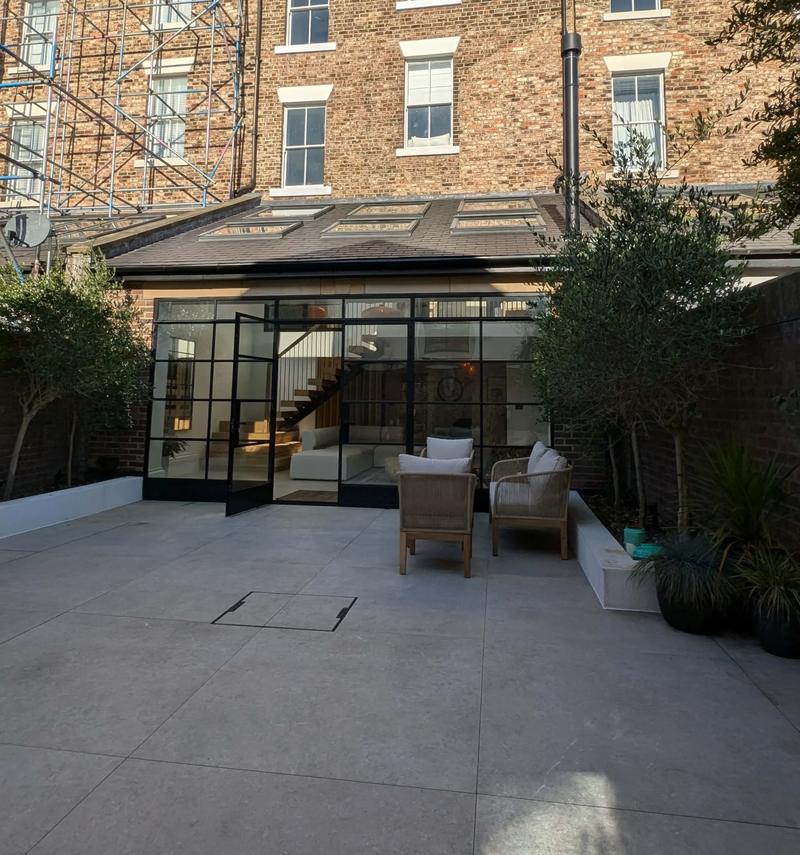 Rear of a renovated period terrace in Newcastle with a glazed ground-floor extension opening onto a paved courtyard
