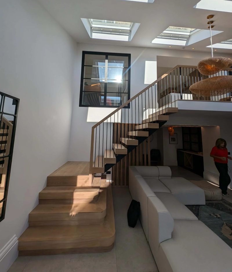 Double-height living space with an oak and steel staircase and rooflights in a remodelled Newcastle home